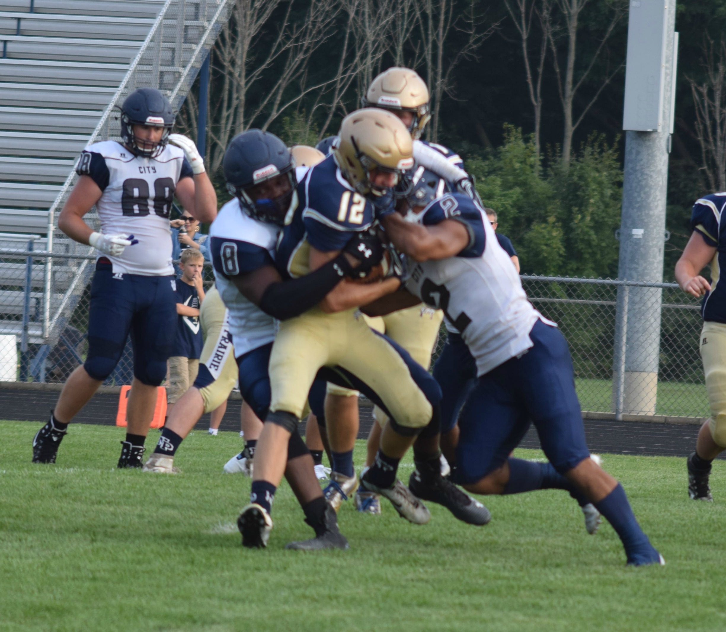 Chase Triplett (8) and Lyric McFarrin (2) put a hit on New Prairie's Tyler Graeber (12)